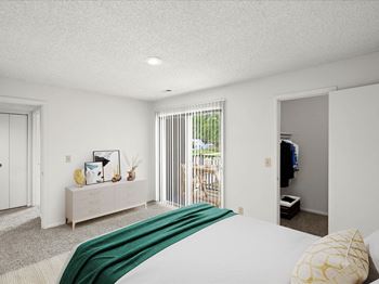 Bedroom with a large comfortable bed and closet and attached patio 